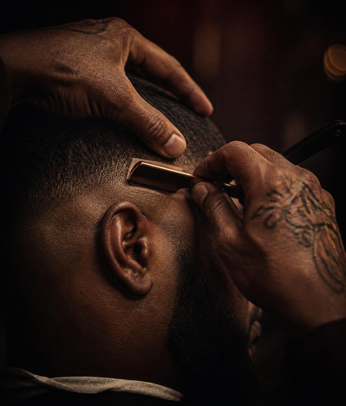 Barber finishing a razor line-up at 7 Star Salon